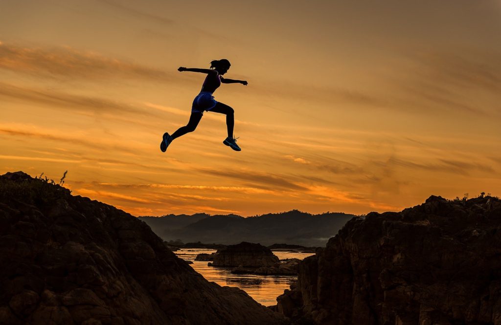 mujer saltando en el atardecer